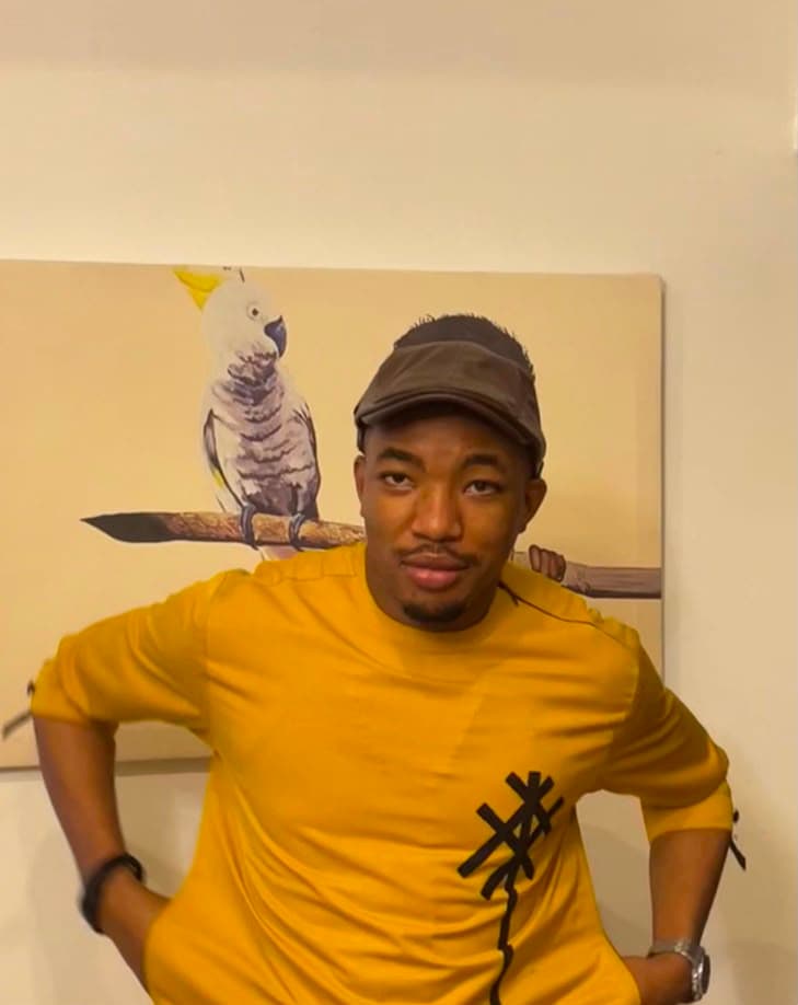Victor Nwachukwu in front of a cockatoo painting